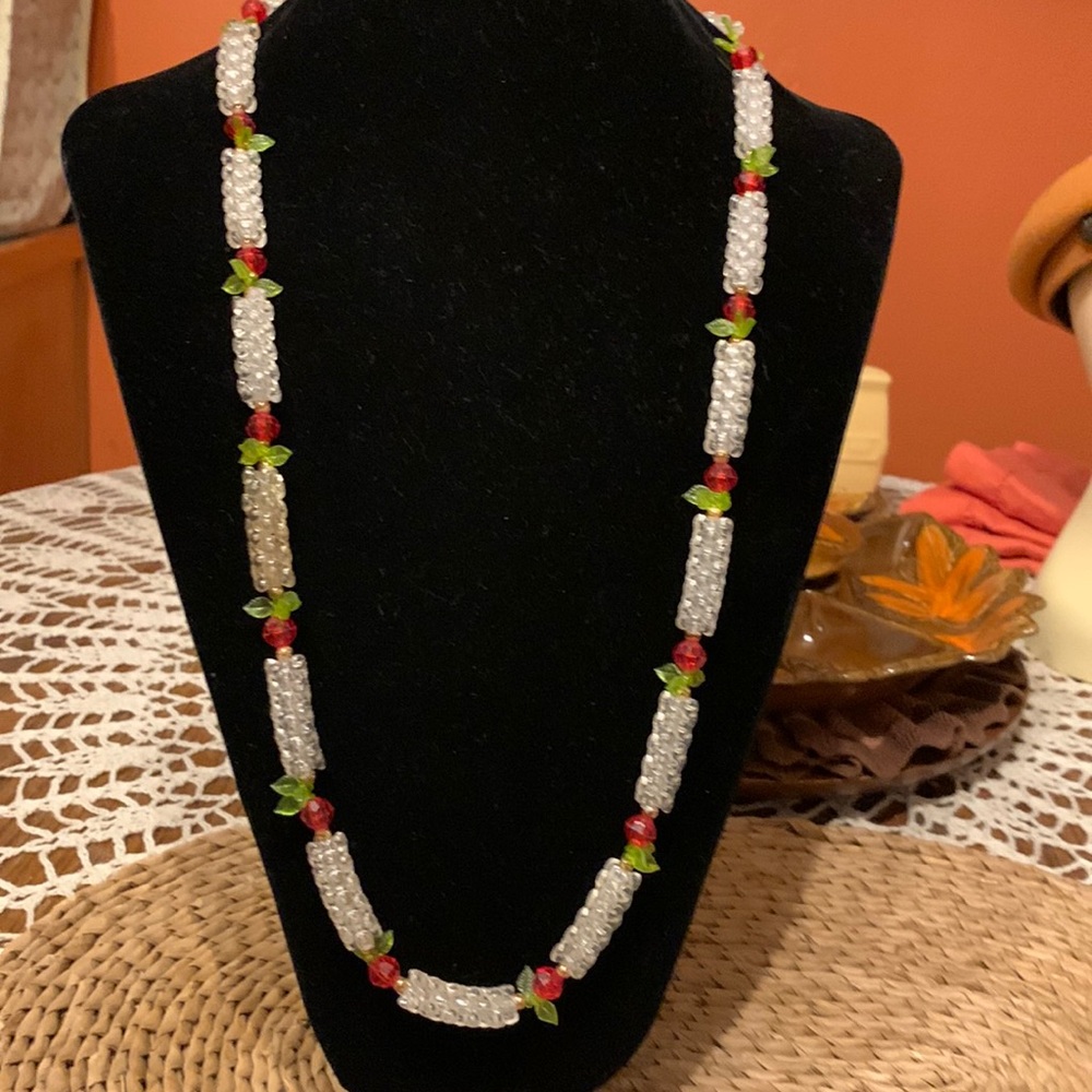 Vintage handmade acrylic necklace clear beads with red beads and green leaves.